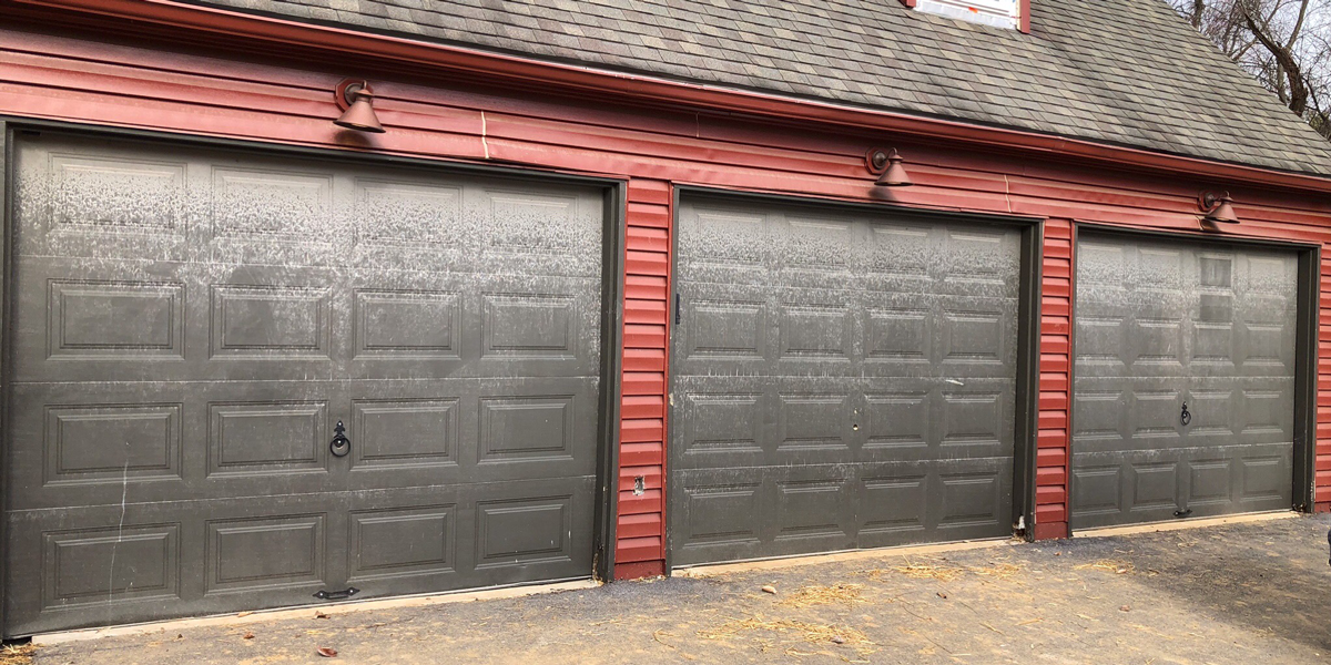 An old, discolored garage door before it was replaced.